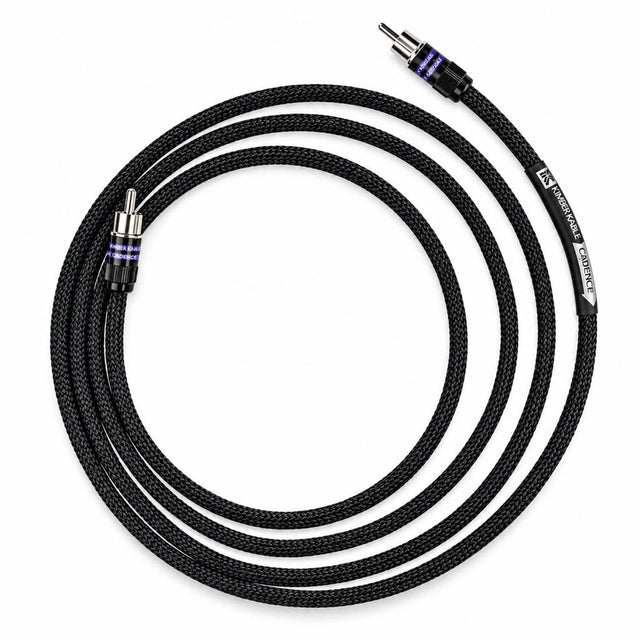 A coiled black braided audio cable with silver RCA connectors, featuring purple accent rings and white branding text on the cable jacket, set against a plain white background.