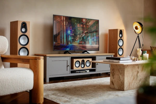 Pair of Monitor Audio Silver 500 7G floorstanding speakers flanking a TV in a living room setup